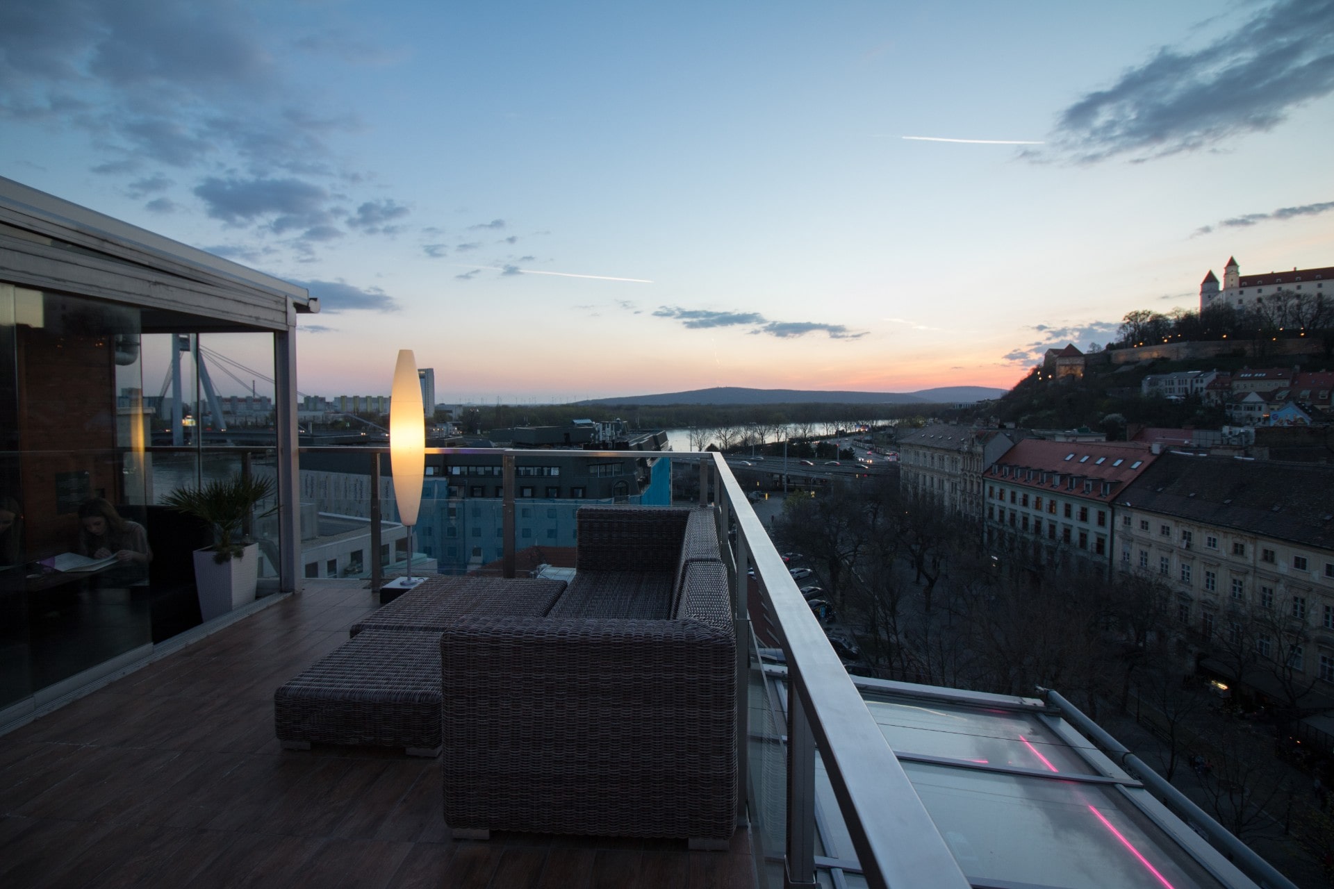 a-rooftop-terrace-with-outdoor-seating-and-lights-at-sunset-skybar-bratislava