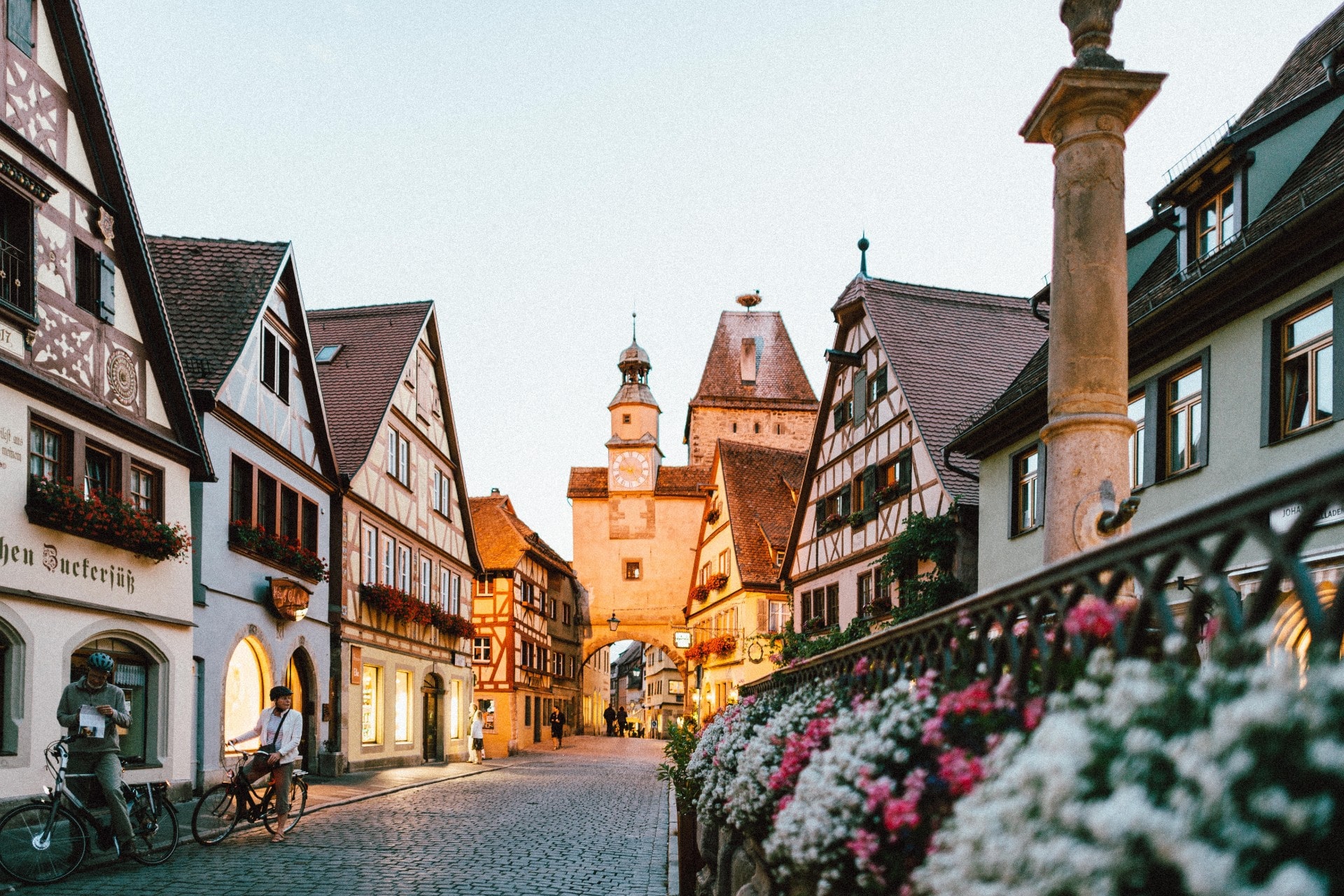 beautiful-fairytale-european-town-city-at-sunset-a-street-of-old-colourful-houses-with-flowers-lit-up-by-lights-at-night-interrail-budget-interrailing-on-a-budget