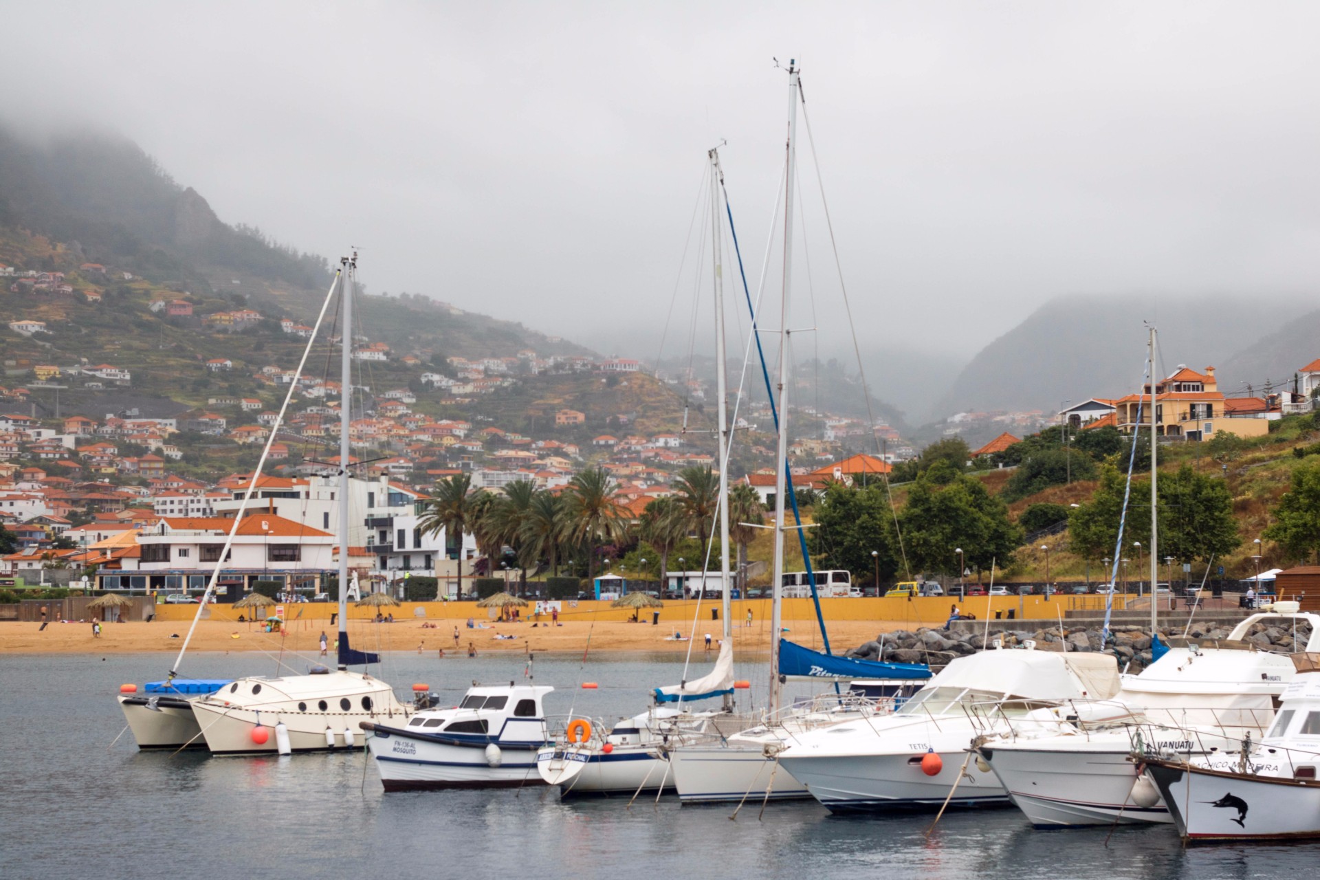 boats-on-water-by-harbour-by-machico-village-in-the-mountains-on-a-misty-day