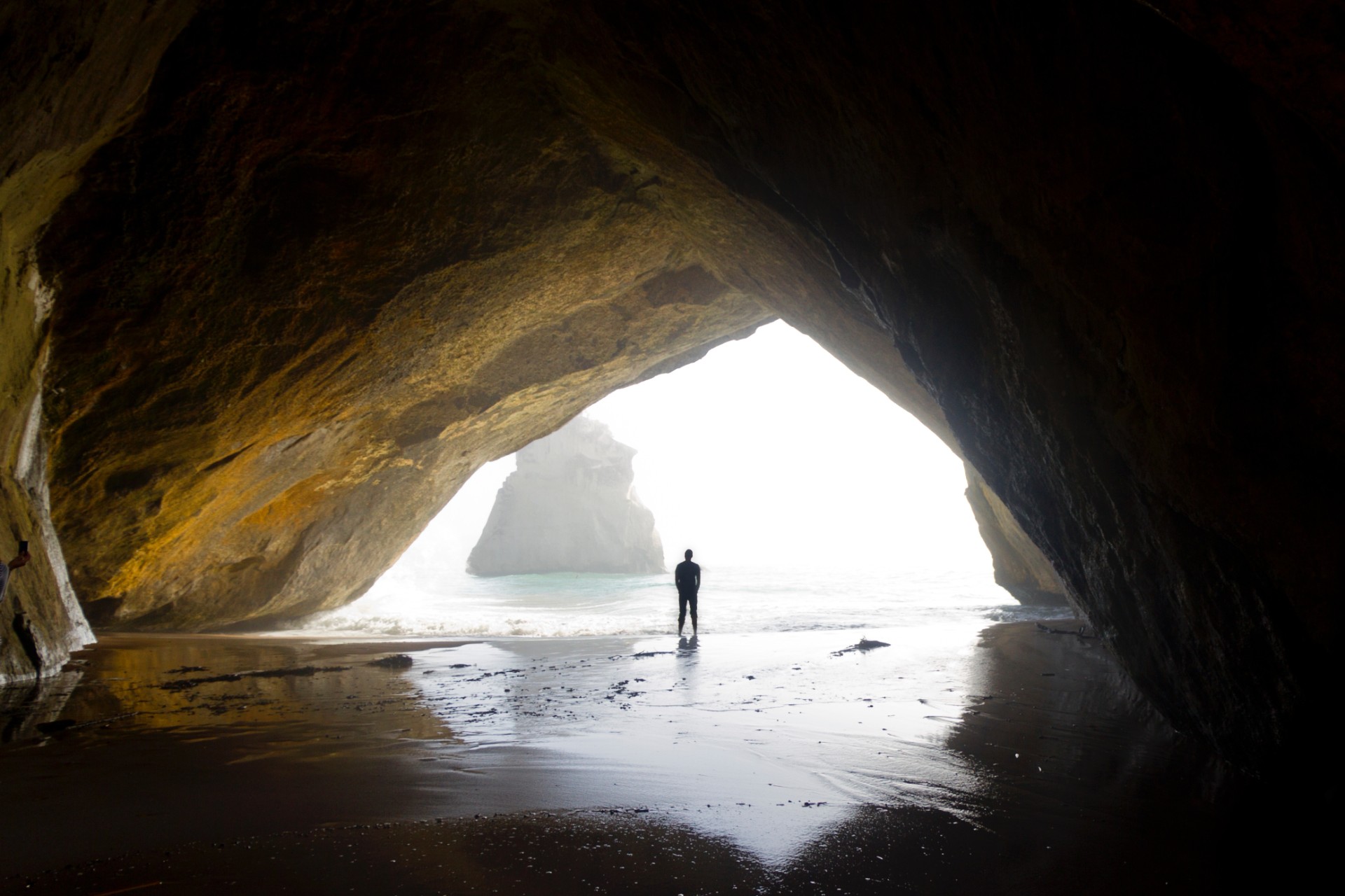 silhouette-of-a-man-standing-within-a-sheltered-cove-on-a-beach-cathedral-cove