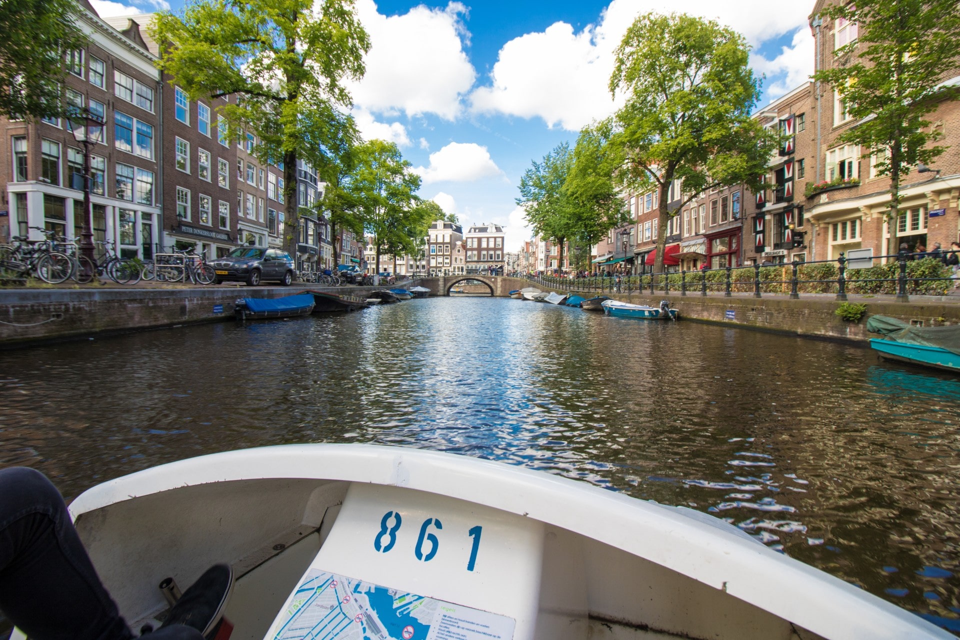 guy-cycling-on-canal-bike-on-a-river-running-through-a-european-city-2-day-amsterdam-itinerary