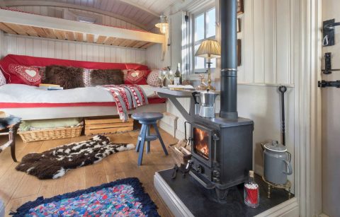 wood-stove-desk-and-sofa-bed-in-cute-shepherds-hut-lake-district-airbnb-canopy-and-stars