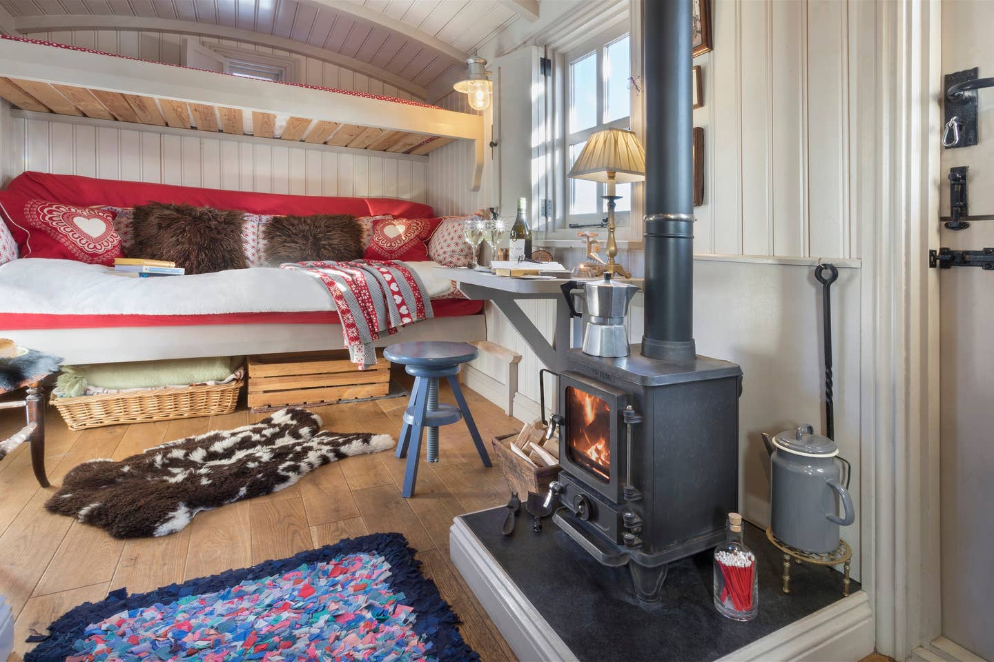 wood-stove-desk-and-sofa-bed-in-cute-shepherds-hut-lake-district-airbnb-canopy-and-stars-unusual-romantic-weekend-breaks-uk
