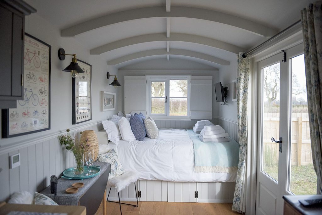 interior-of-a-shepherds-hut-clean-white-minimalist-decor-and-bed-waingates-farm-huts-roecliffe