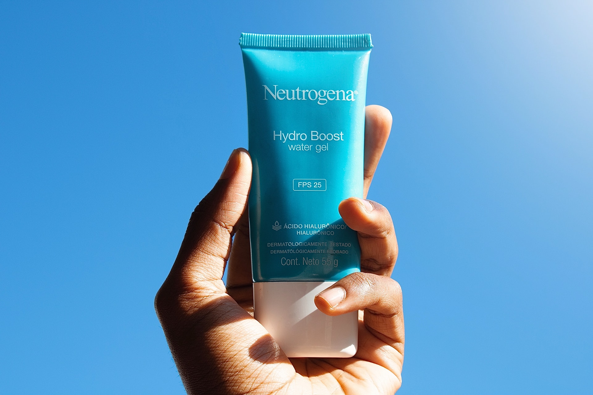 hand-holding-sunscreen-suncream-against-a-blue-sky-neutrogena-hydro-boost-water-gel-spf-25