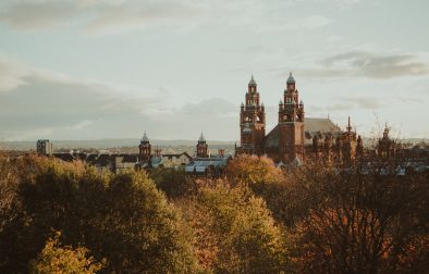 old-historic-building-in-city-poking-over-trees-in-autumn-2-days-in-glasgow
