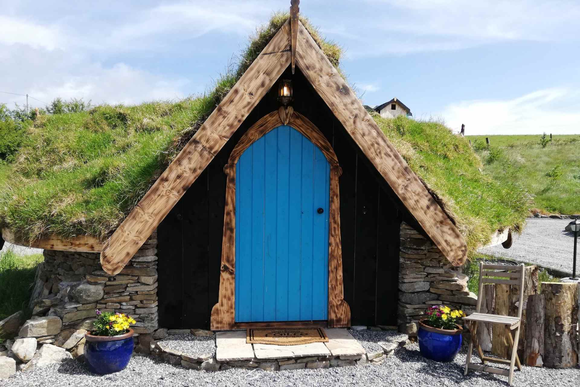 an-claddagh-fairy hut-under-grassy-hill-with-blue-door