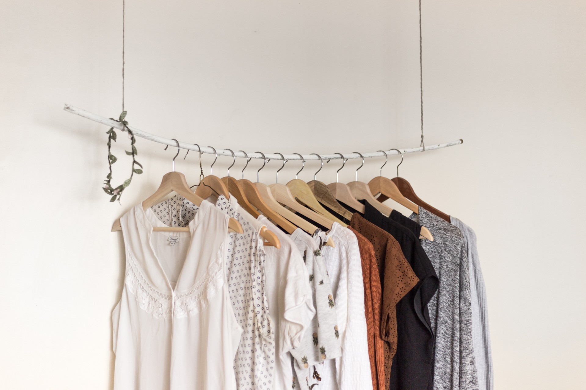 clothes-hanging-from-hanging-rail-from-ceiling-in-white-minimalist-room-travel-capsule-wardrobe
