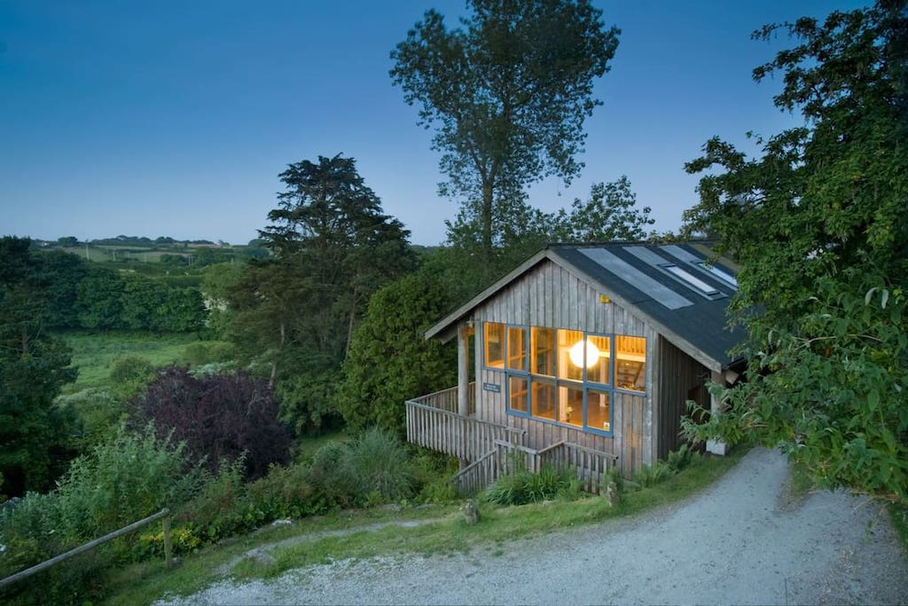 peaceful-country-treehouse-lit-up-at-sunset-in-field-in-penzance-best-airbnbs-in-cornwall