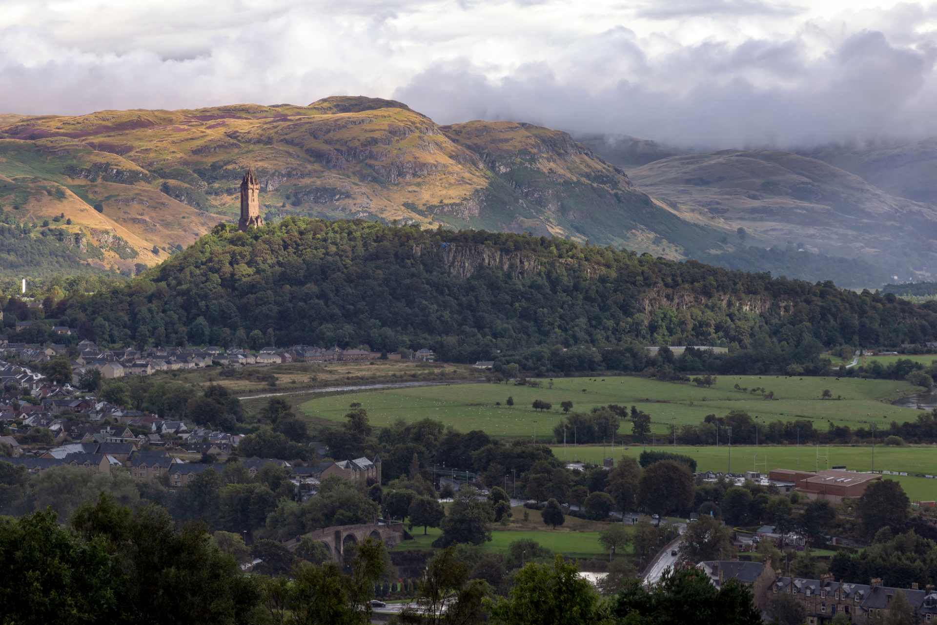 view-of-the-national-wallace-monument-and-surrounding-fields-and-mountains-in-stirling