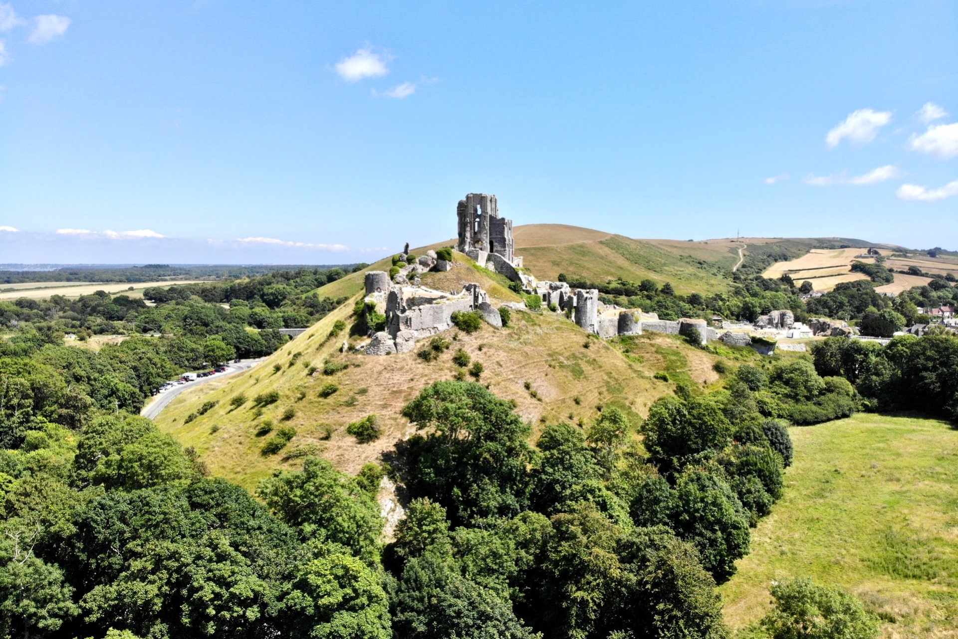 corfe-castle-sat-on-top-of-green-hill-in-summer-castles-in-dorset