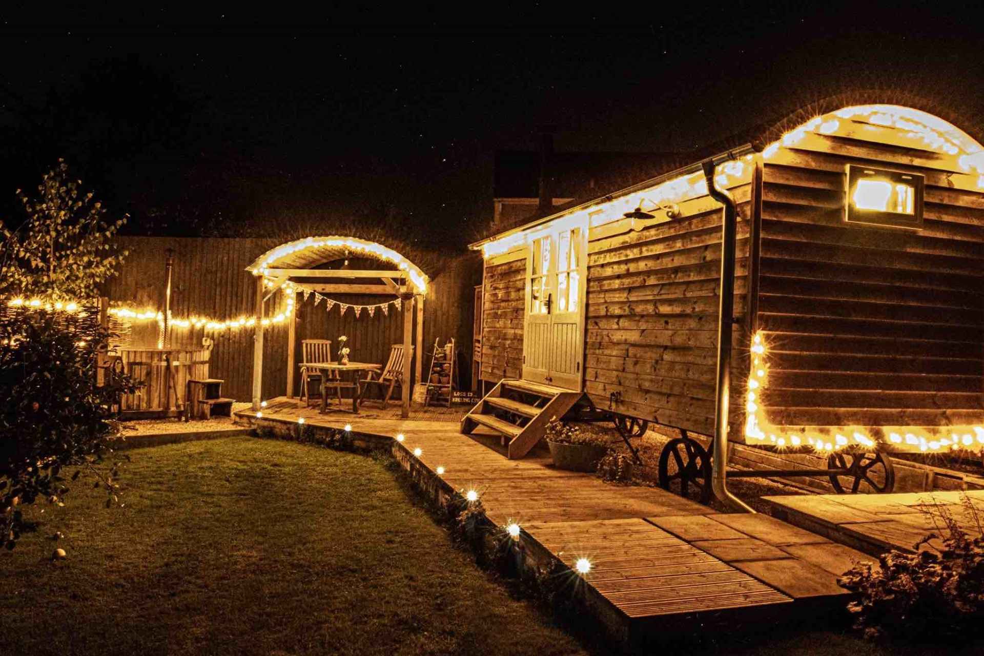 esmes-escape-shepherds-hut-on-decking-lit-up-at-night