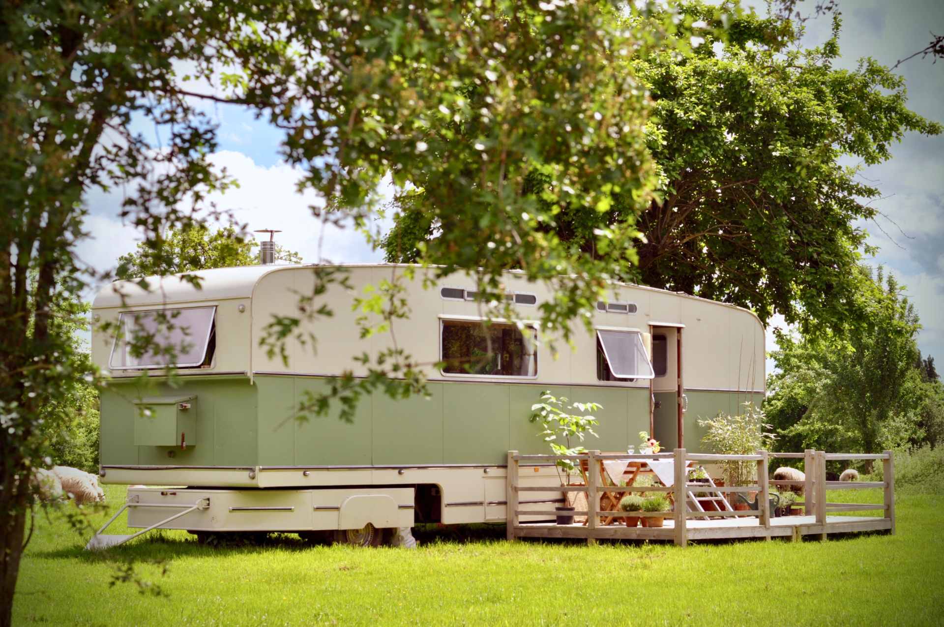 green-and-white-sipson-caravan-with-decking-in-field-on-sunny-day