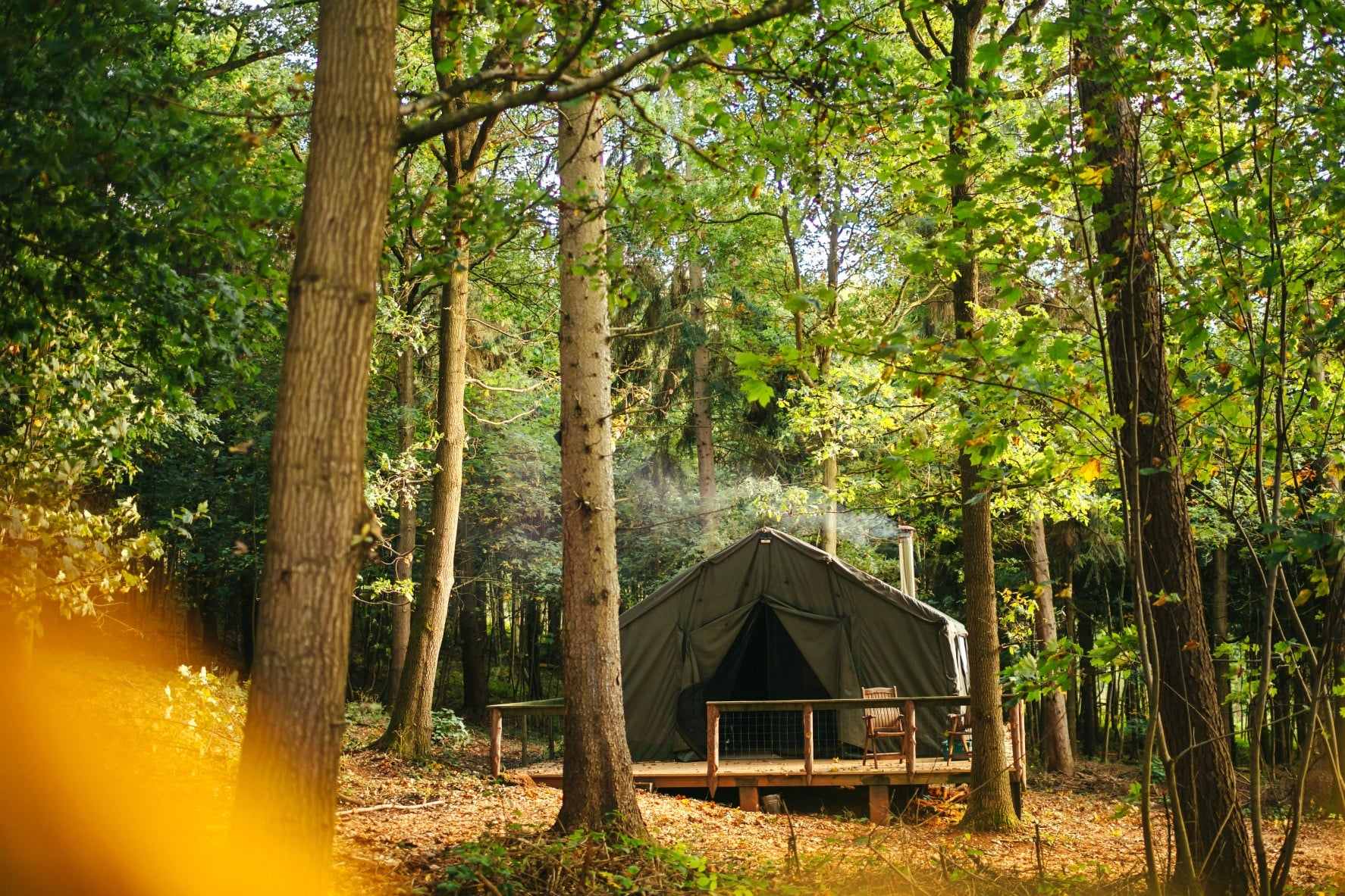 green-officers-hideaway-safari-tent-on-decking-in-forest-on-sunny-day-glamping-herefordshire