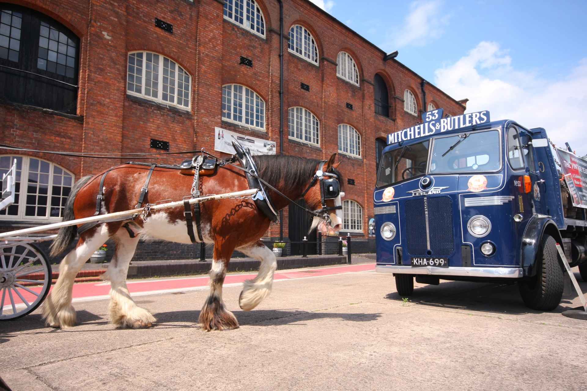 horse-pulling-cart-and-blue-truck-by-brick-building-at-national-brewery-centre-burton-upon-trent