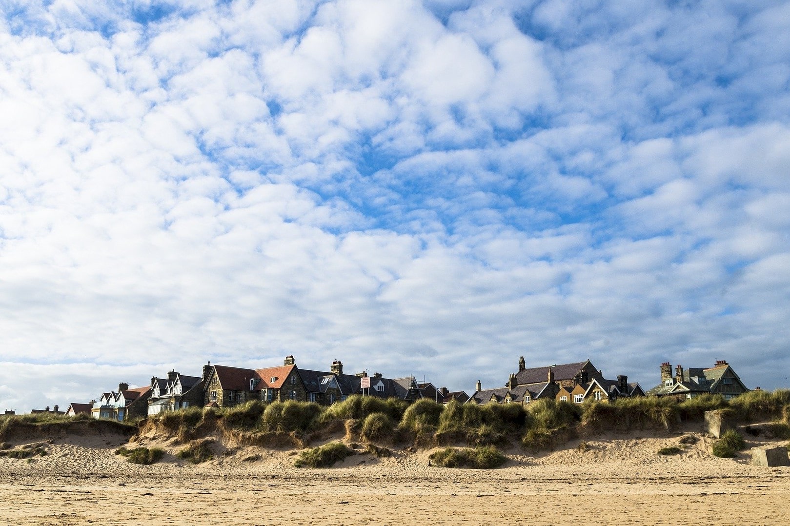 houses-alongside-beach-sand-dunes-on-sunny-day-in-alnmouth-best-places-to-visit-in-northumberland
