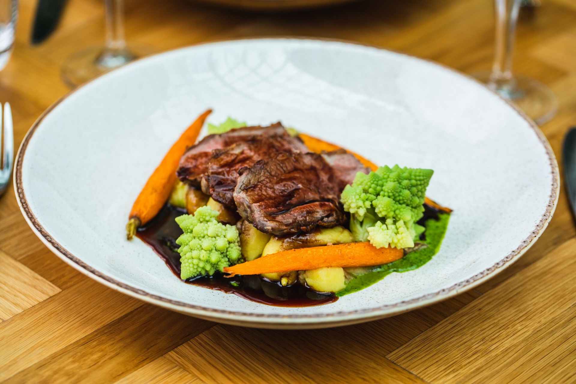 lamb-vegetables-and-gravy-in-white-bowl-on-table-at-aria-restaurant-the-hyatt