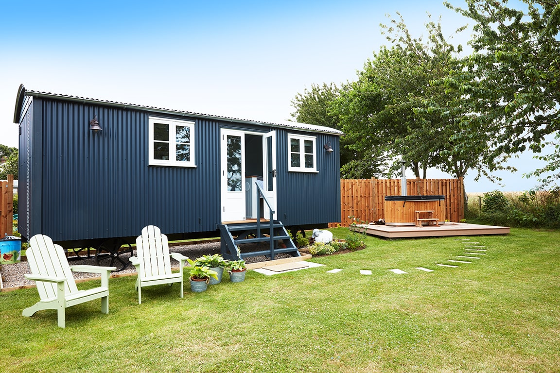 large-luxury-navy-shepherds-hut-in-field-with-woodfired-hot-tub-glamping-norfolk