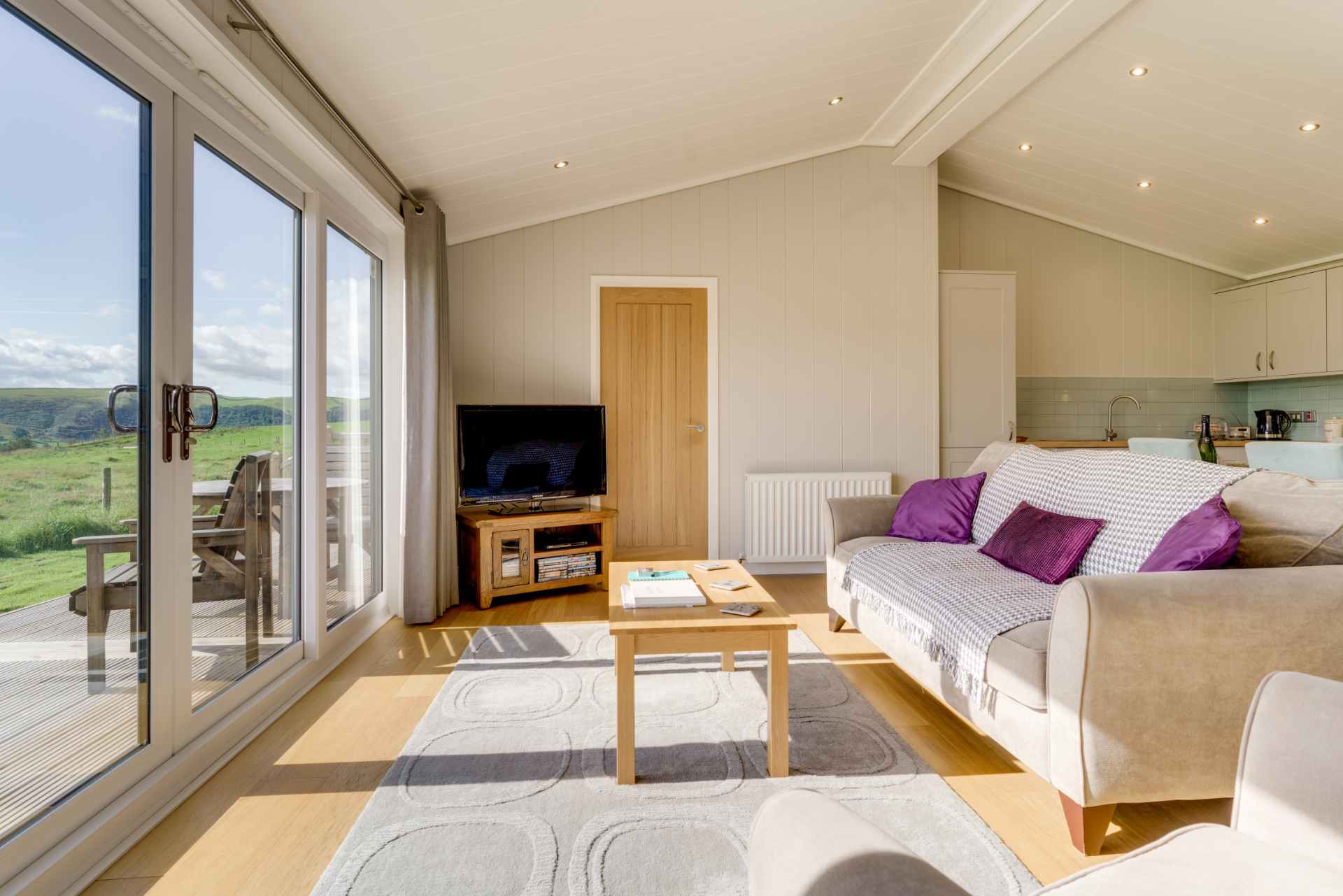 modern-living-area-in-holiday-home-cedar-wood-lodge-with-glass-doors-overlooking-cockermouth-countryside
