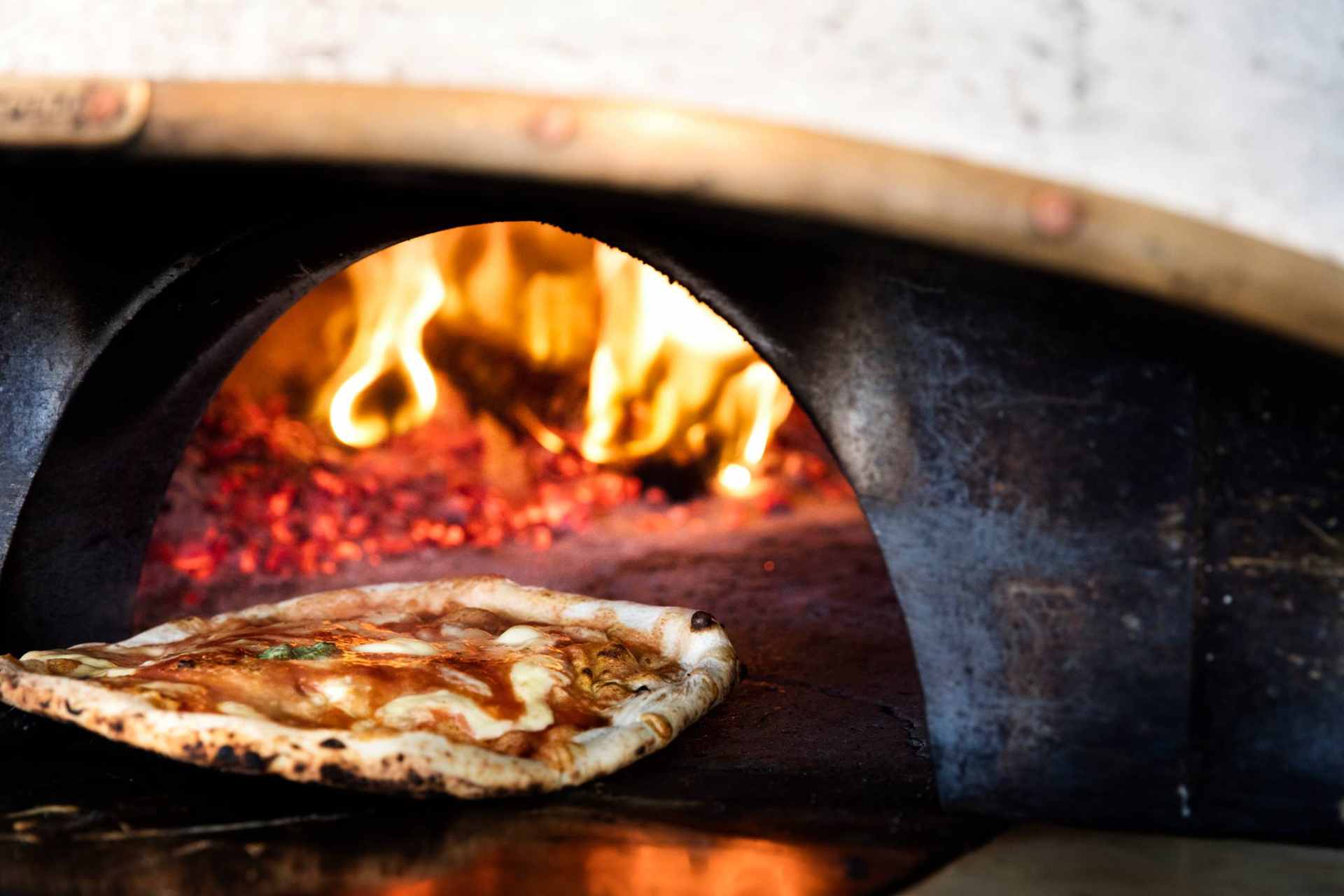 pizza-going-into-woodfired-pizza-oven-at-mother-restaurant-3-days-in-copenhagen-itinerary