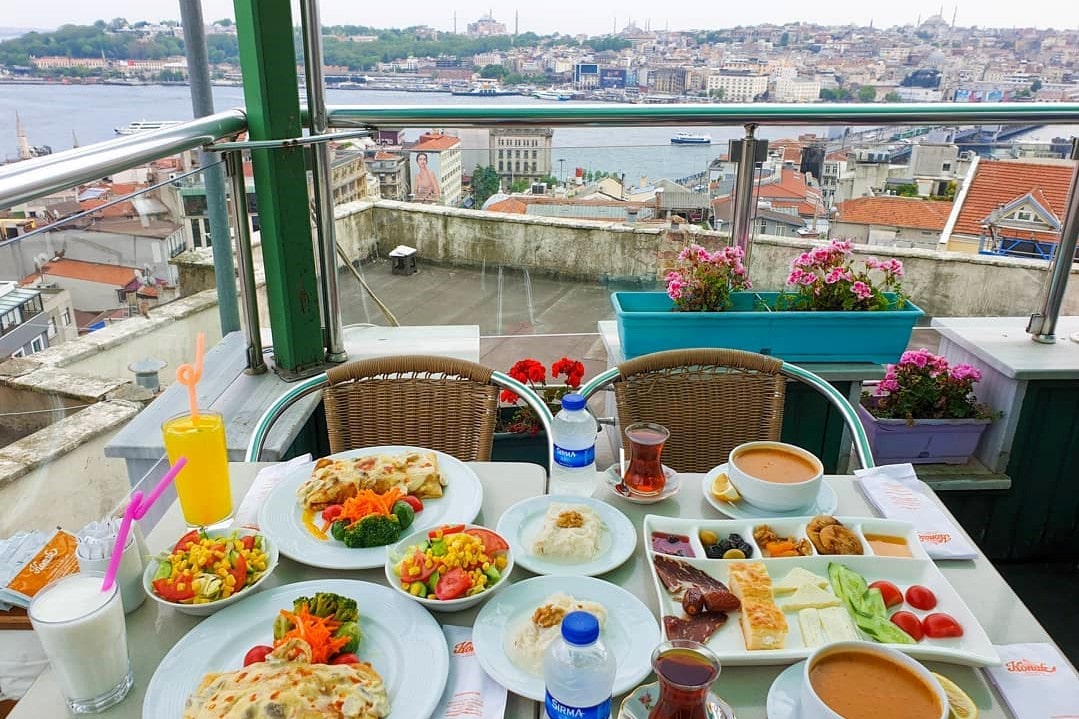rooftop-restaurant-table-of-turkish-food-with-view-overlooking-harbour-galata-konak-café