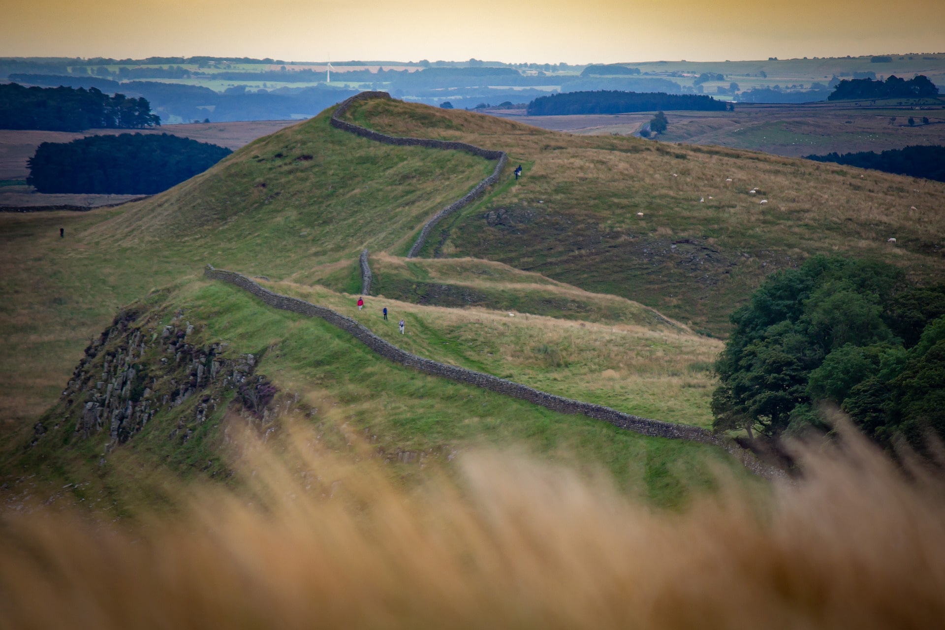 rubble-wall-hadrians-wall-winding-through-countryside-hills-at-sunset-best-places-to-visit-in-northumberland
