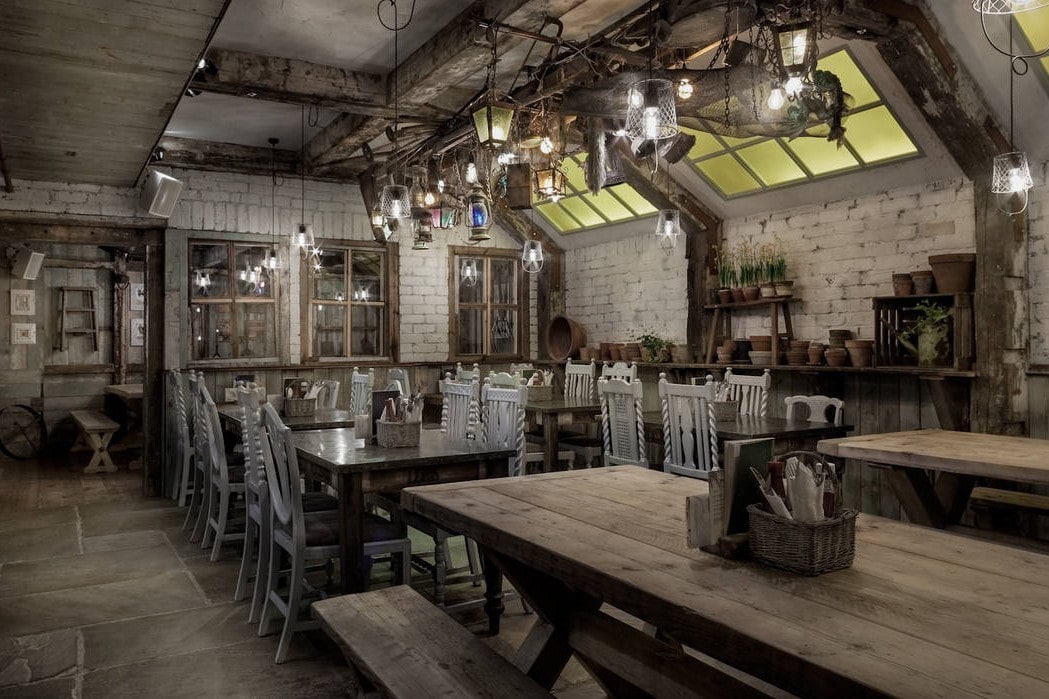 rustic-industrial-restaurant-room-with-tables-benches-and-chairs-at-the-botanist