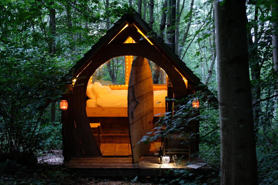 small-hobbit-house-lit-up-with-fairy-lights-in-evening-at-brook-house-woods-glamping-herefordshire