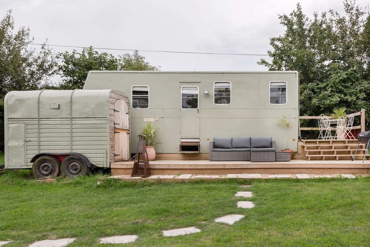 stepping-stones-leading-to-mint-vintage-horsebox-on-decking-in-garden