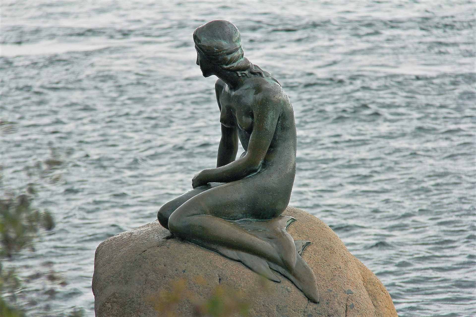 the-little-mermaid-statue-sat-on-rock-by-water