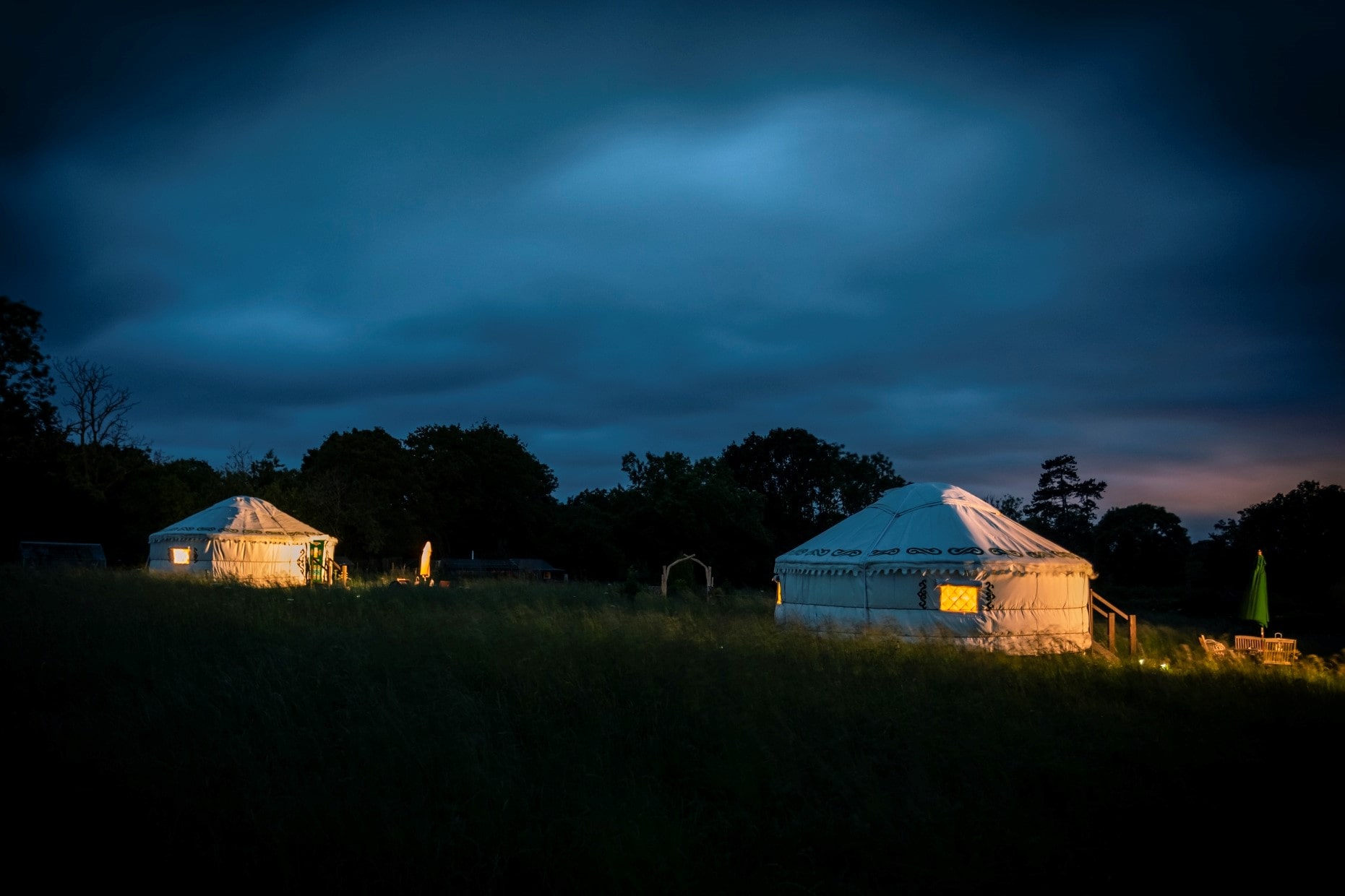 two-white-yurts-lit-up-at-night-at-the-wildflower-meadow