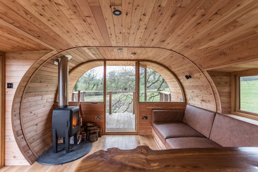 woodburner-and-sofa-in-living-area-of-cheriton-treehouse-somerset-glamping