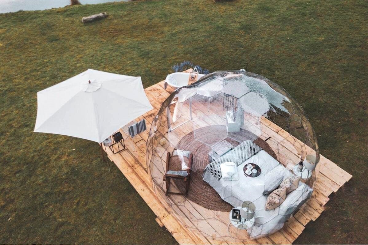 aerial-view-of-transparent-geodome-with-bed-in-field