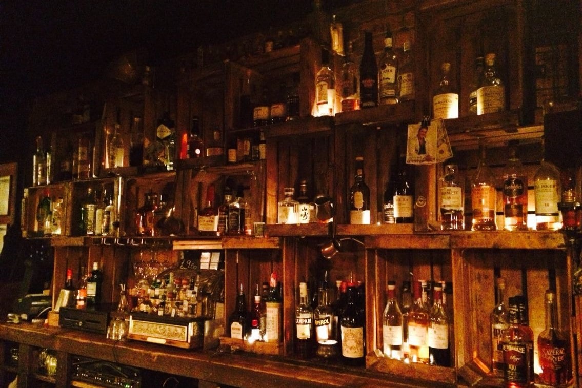 alcohol-behind-wooden-bar-at-berry-and-rye