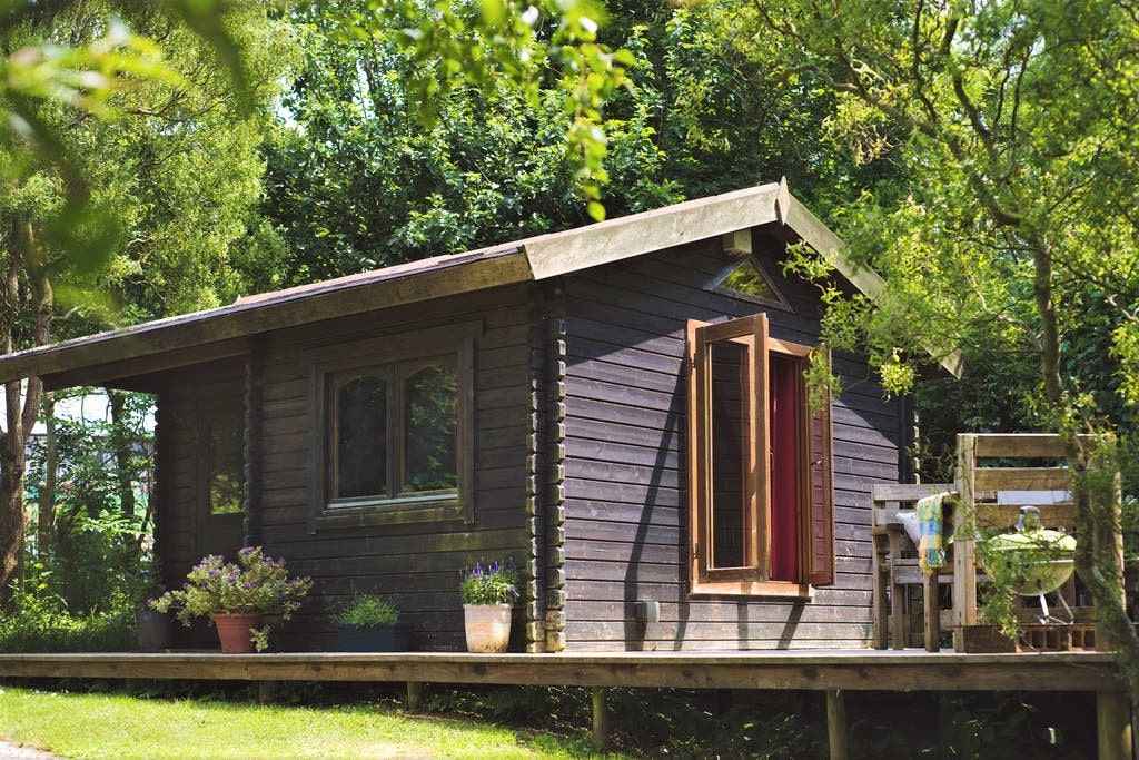 cosy-orchard-cabin-on-decking-with-trees-behind