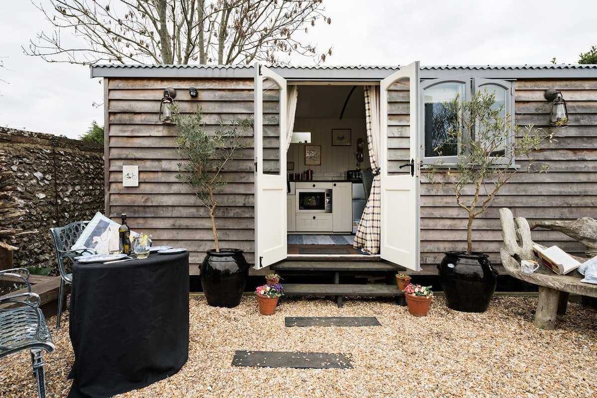 exterior-of-shepherds-hut-with-doors-open-and-outdoor-seating