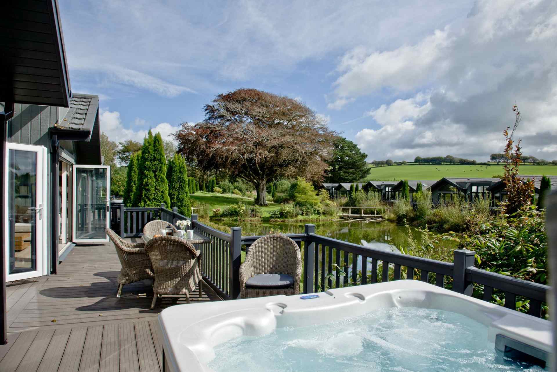 hot-tub-on-decking-of-kentisbury-grange-lodges-overlooking-lake-lodges-with-hot-tubs-devon