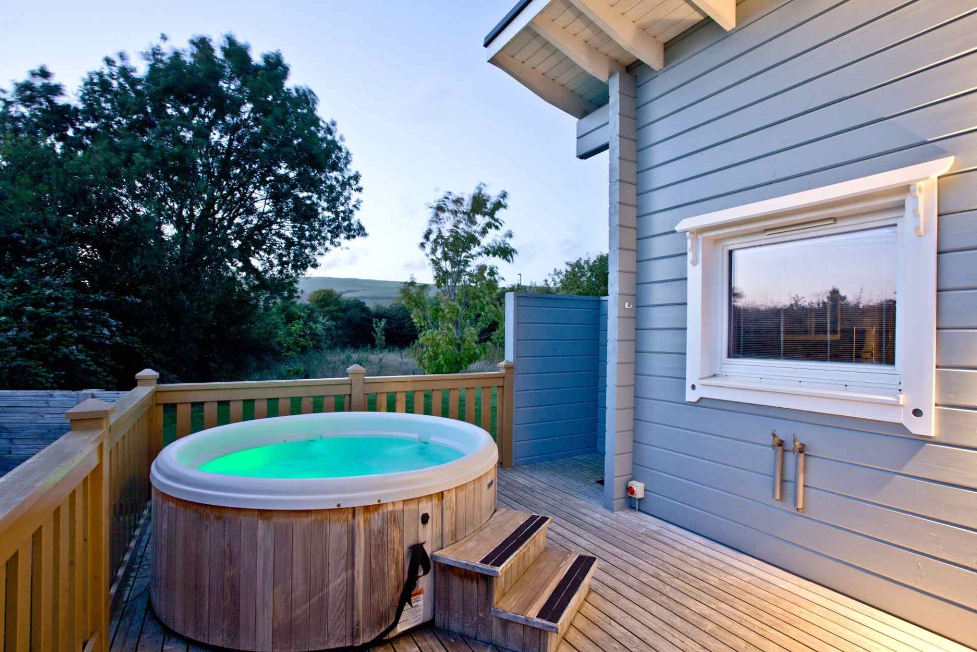 hot-tub-on-decking-of-lodge-at-great-field-lodges-at-sunset-lodges-with-hot-tubs-devon