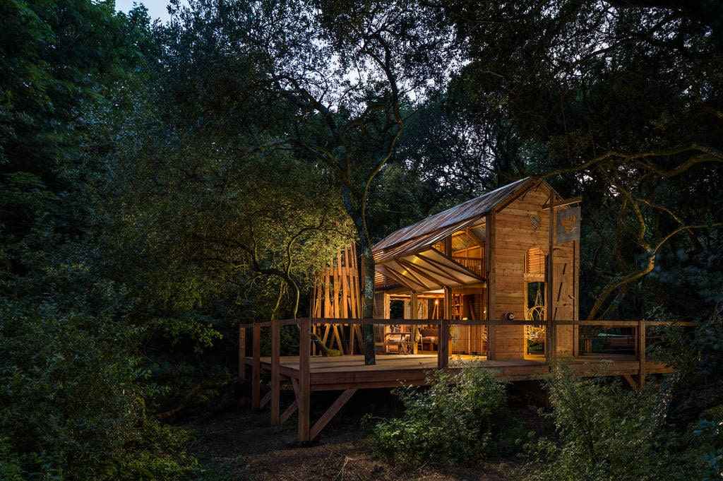 the-danish-cabin-lit-up-in-the-evening-in-woodland-at-kudhva-glamping-with-hot-tub-cornwall