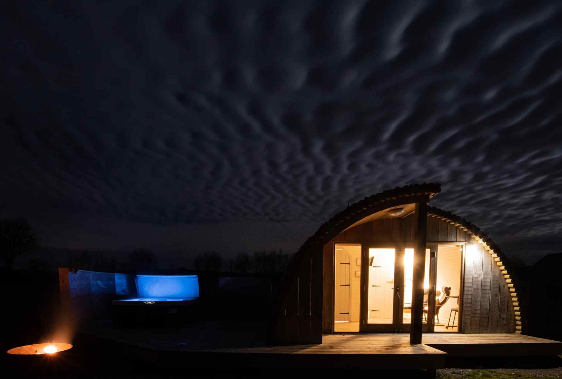 three-moors-view-log-cabin-with-hot-tub-lit-up-at-night-lodges-with-hot-tubs-devon