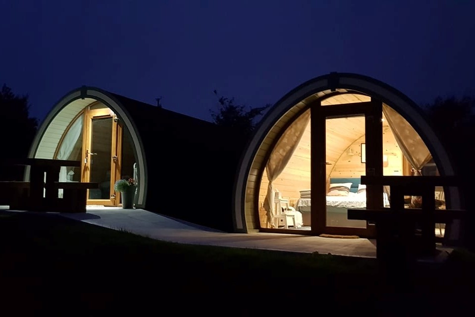 two-eyeries-glamping-pods-lit-up-at-night