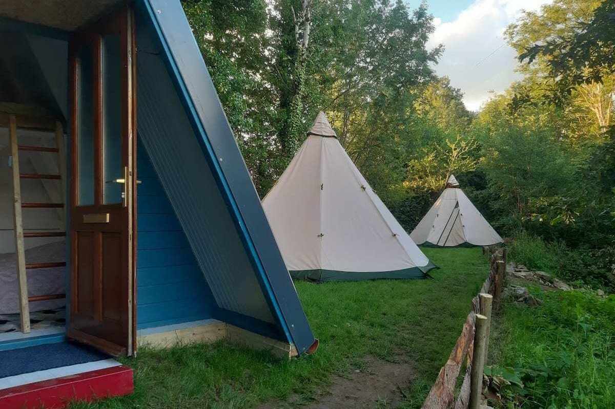 two-white-tipis-by-a-frame-cabin-at-wilton-mills-teepees-glamping-wexford