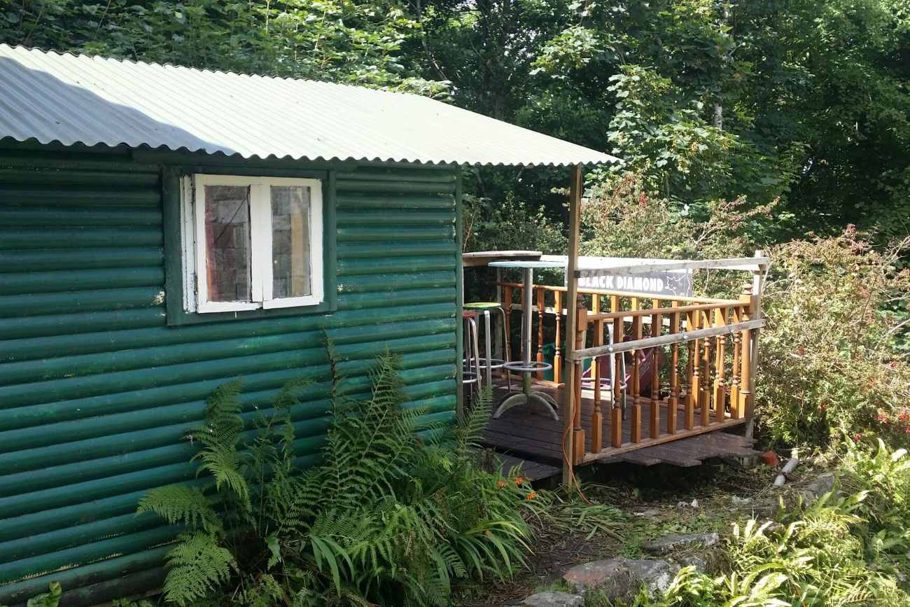 teal-waterfall-hut-with-decking-in-forest