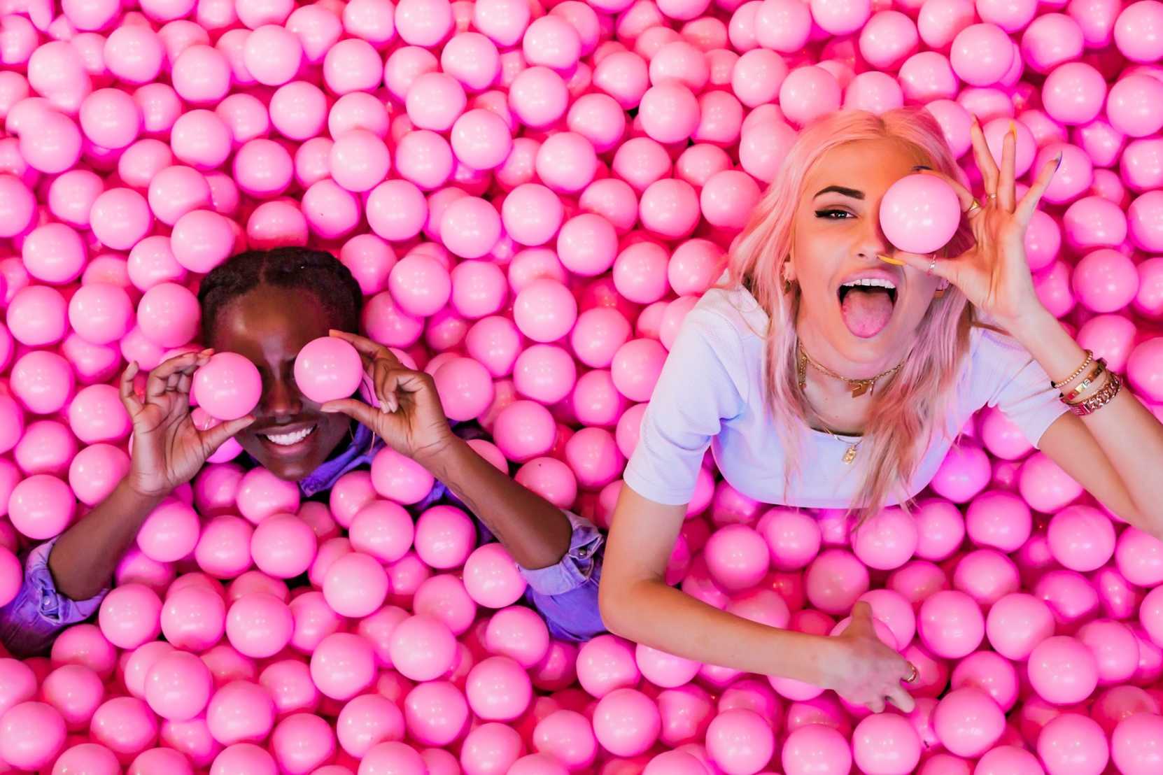 two-young-women-in-pink-ball-pit-at-ballie-ballerson