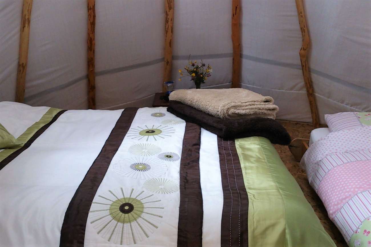 beds-and-towels-inside-pink-apple-orchard-tipi