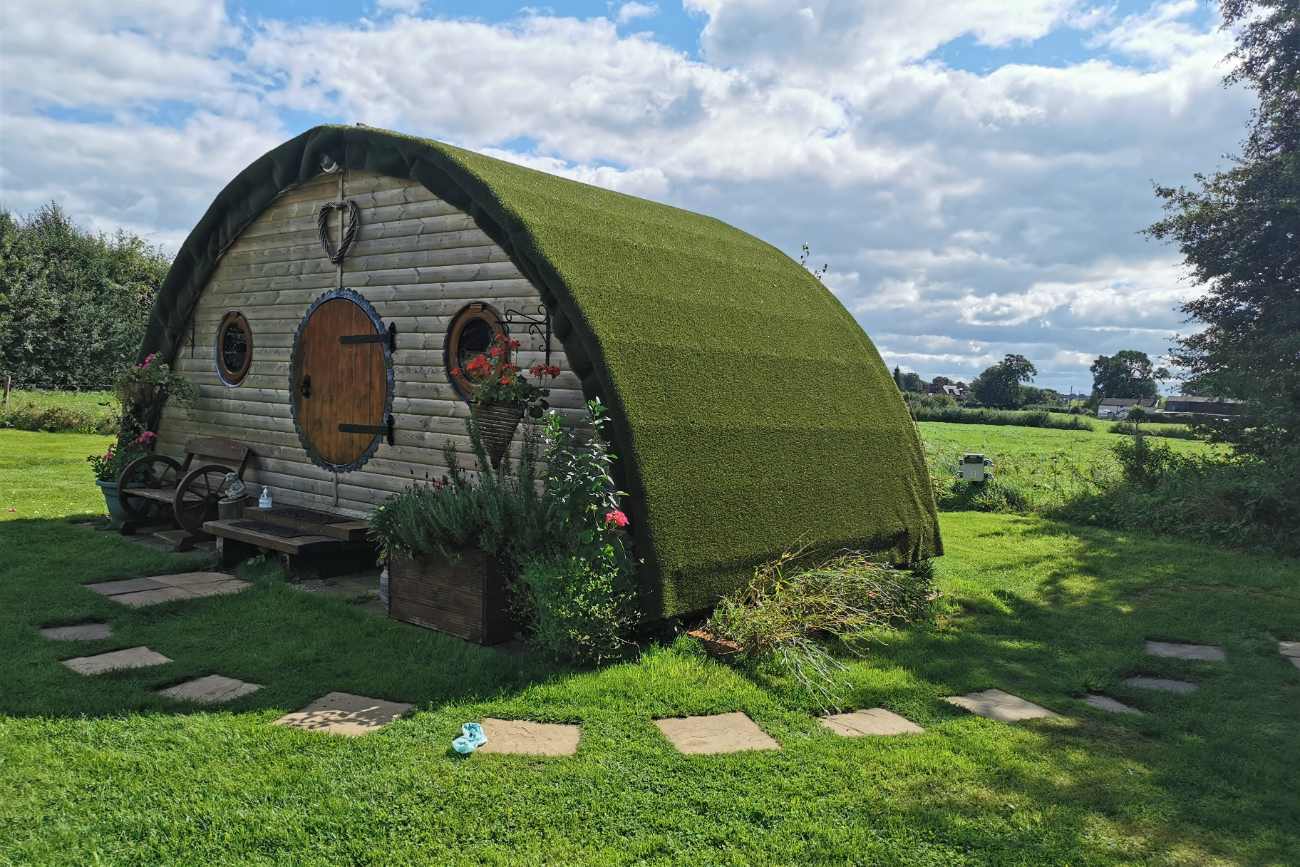 exterior-of-hobbit-retreat-cabin-in-field