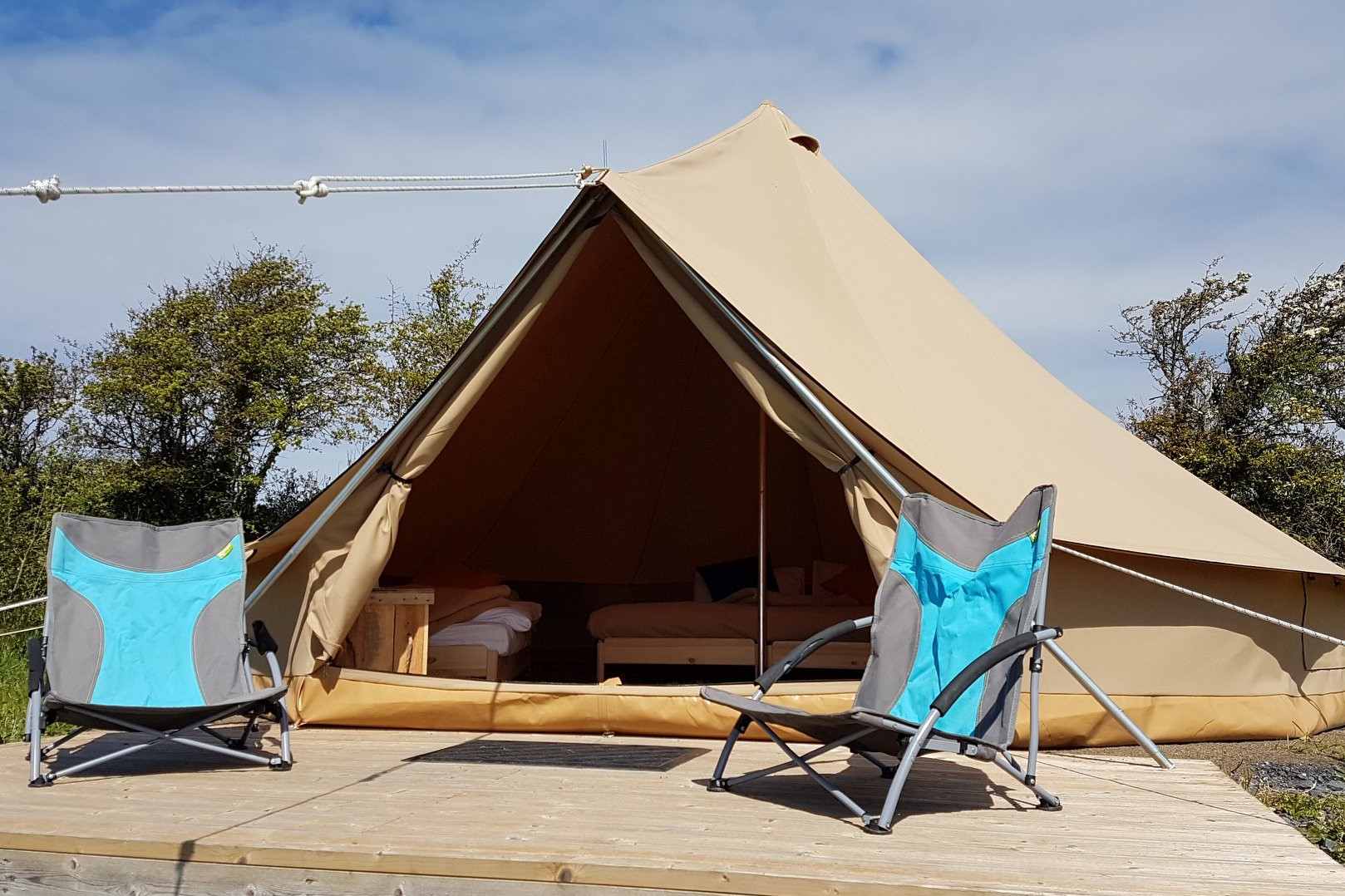 pure-camping-bell-tent-with-camping-chairs-on-decking