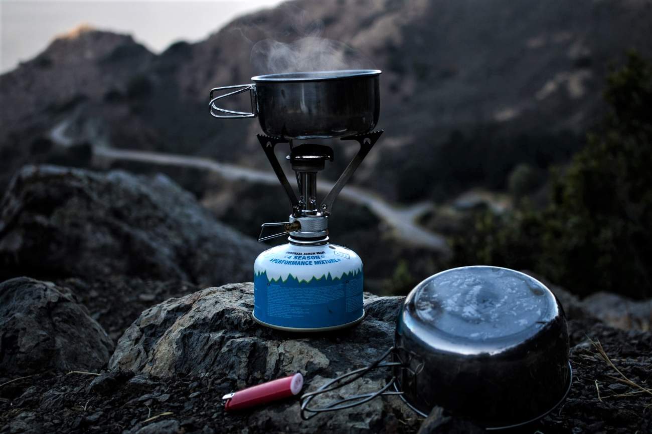 camp-stove-cooking-food-on-rock