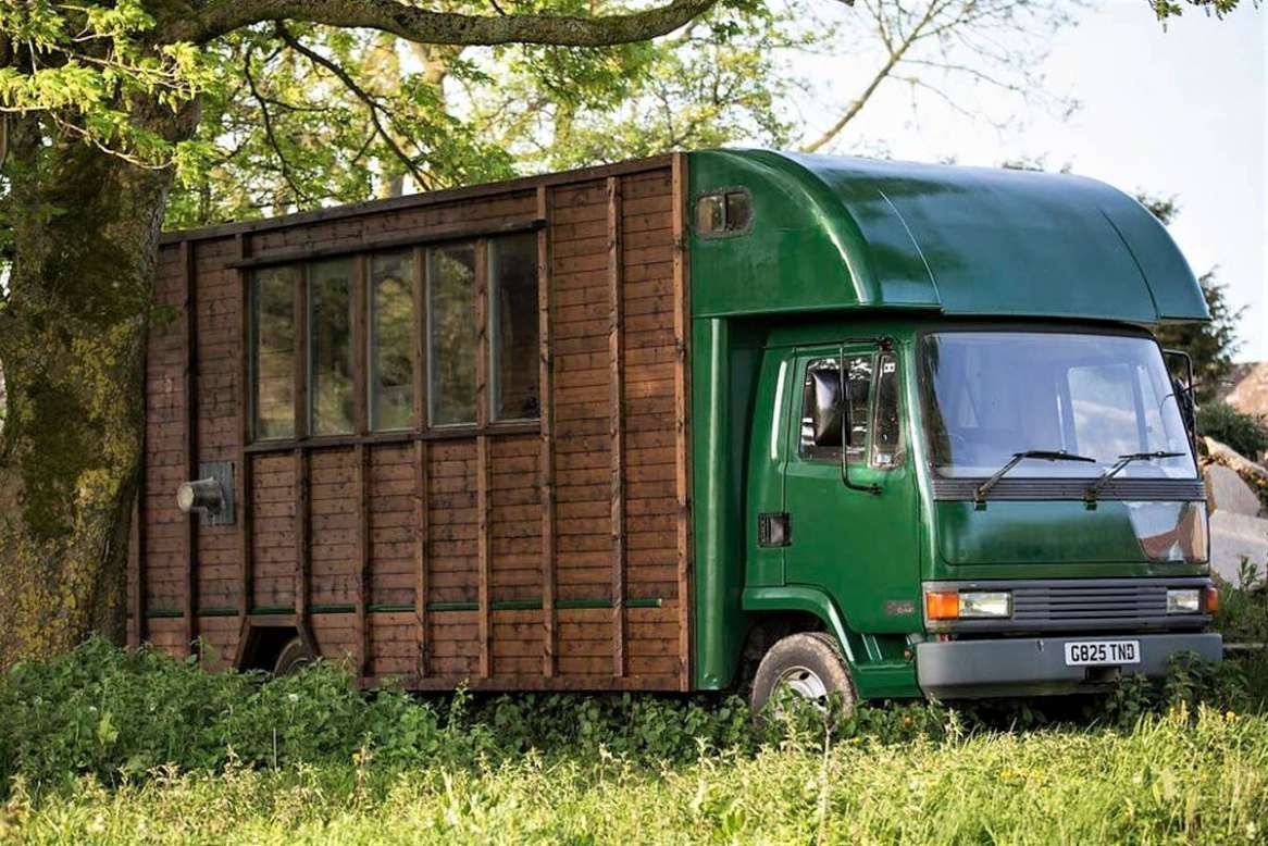 green-and-brown-converted-horse-lorry-in-field