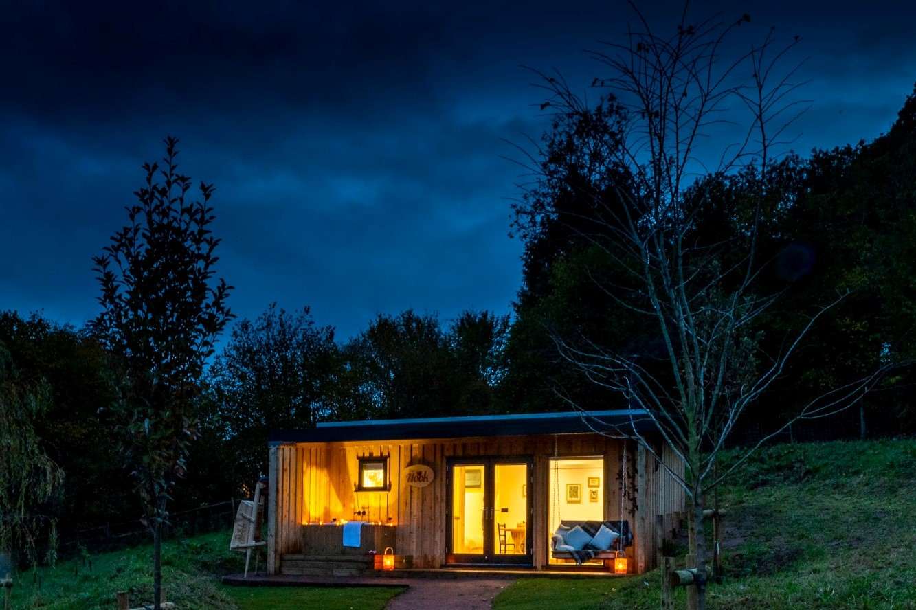 the-nook-cabin-at-the-roost-glamping-lit-up-at-night-glamping-gloucestershire